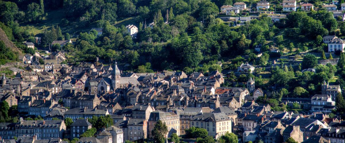 A densely packed historic town with numerous buildings and a prominent church steeple.
