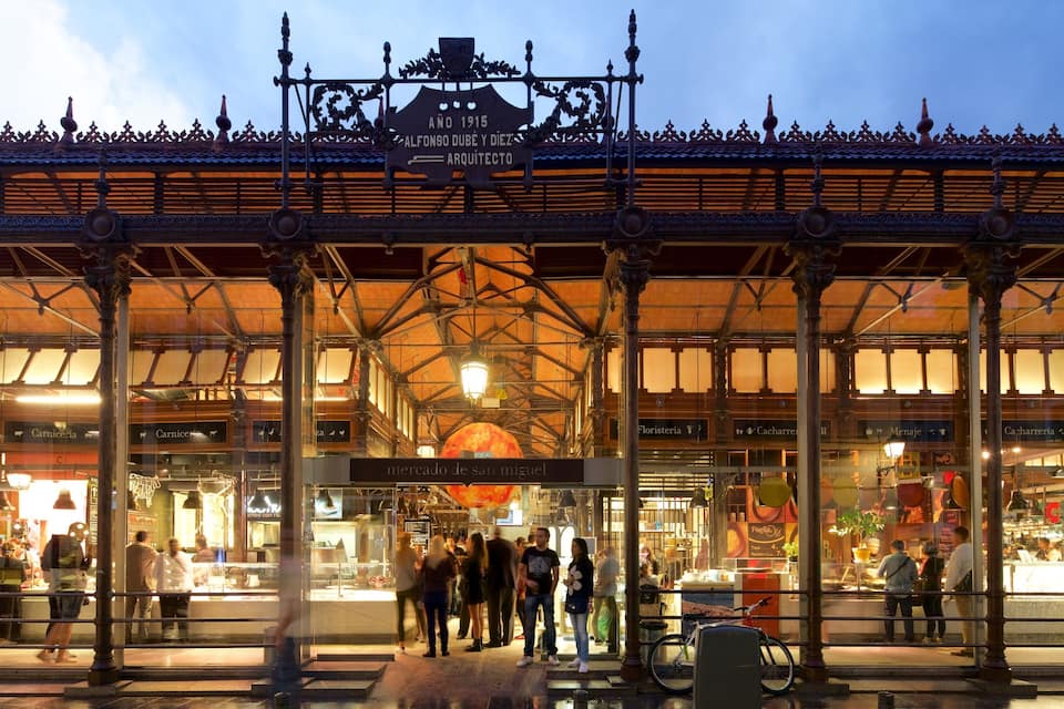 Un marché couvert à l’architecture richement décorée, avec une grande horloge.