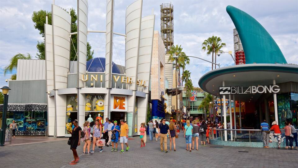 A busy street with a large building labeled "UNIVERSAL STUDIOS" and a curved blue structure with "BILLABONG" signage.