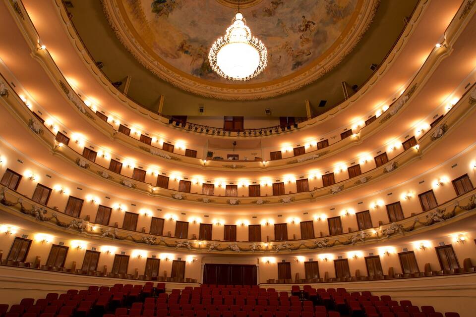 Un vaste théâtre à plusieurs niveaux, doté de décorations somptueuses et d’un grand lustre.