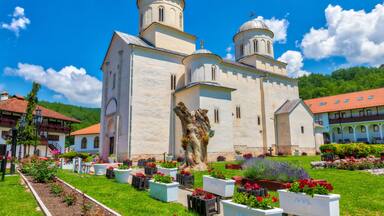 Eine Kirche mit zwei Kuppeln, umgeben von einem gepflegten Garten mit verschiedenen Blumen und Pflanzen.