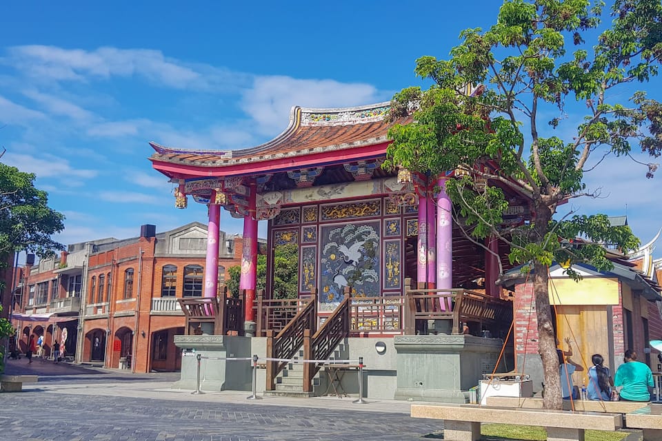 A traditional Chinese building with intricate designs and a red roof.