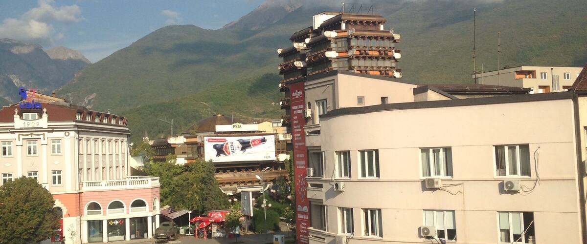 A street with buildings and mountains in the background.