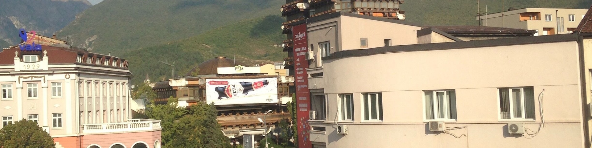 A street with buildings and mountains in the background.