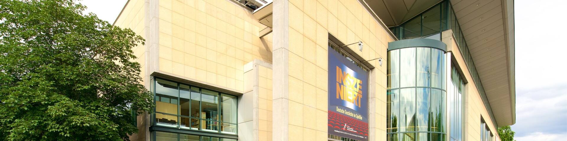 A modern building with large glass windows and a prominent curved glass section.