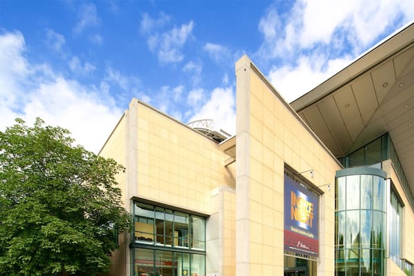 A modern building with large glass windows and a prominent curved glass section.