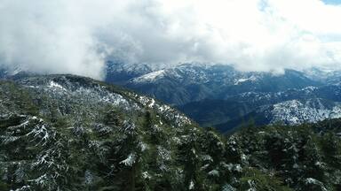 Une chaîne de montagnes aux sommets enneigés, avec une vallée en contrebas.