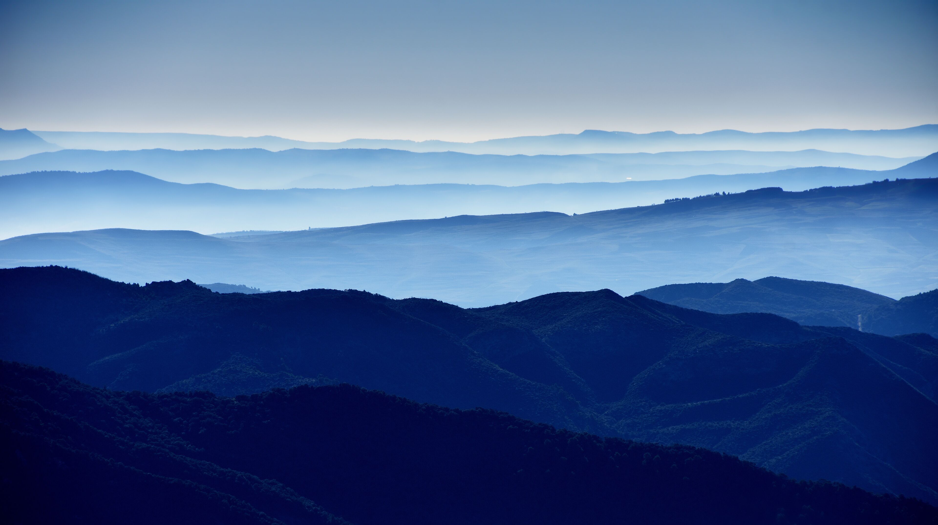 A layered mountain range with a misty atmosphere.