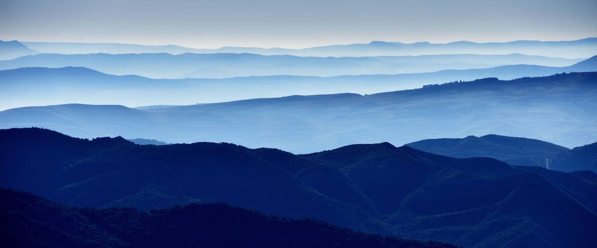 A layered mountain range with a misty atmosphere.