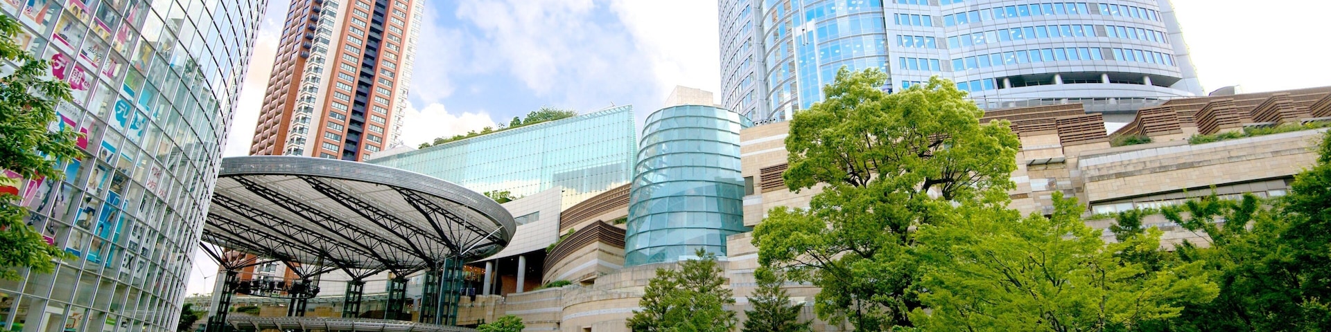 A modern urban park with a pond, lush greenery, and contemporary architecture including high-rise buildings.