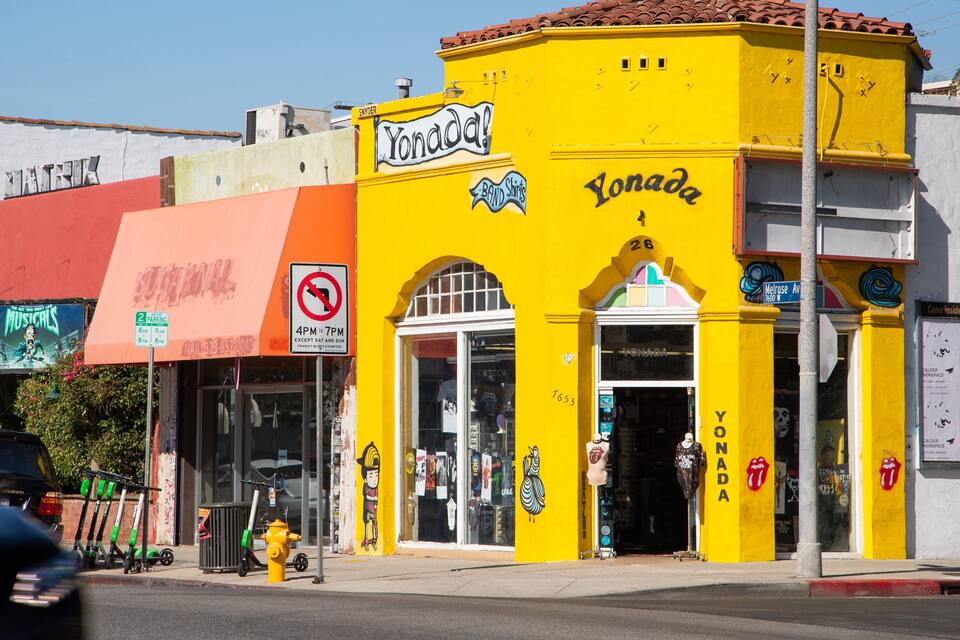 A yellow building with 'YONADA' signage and 'BAND SHIRTS' on the window.