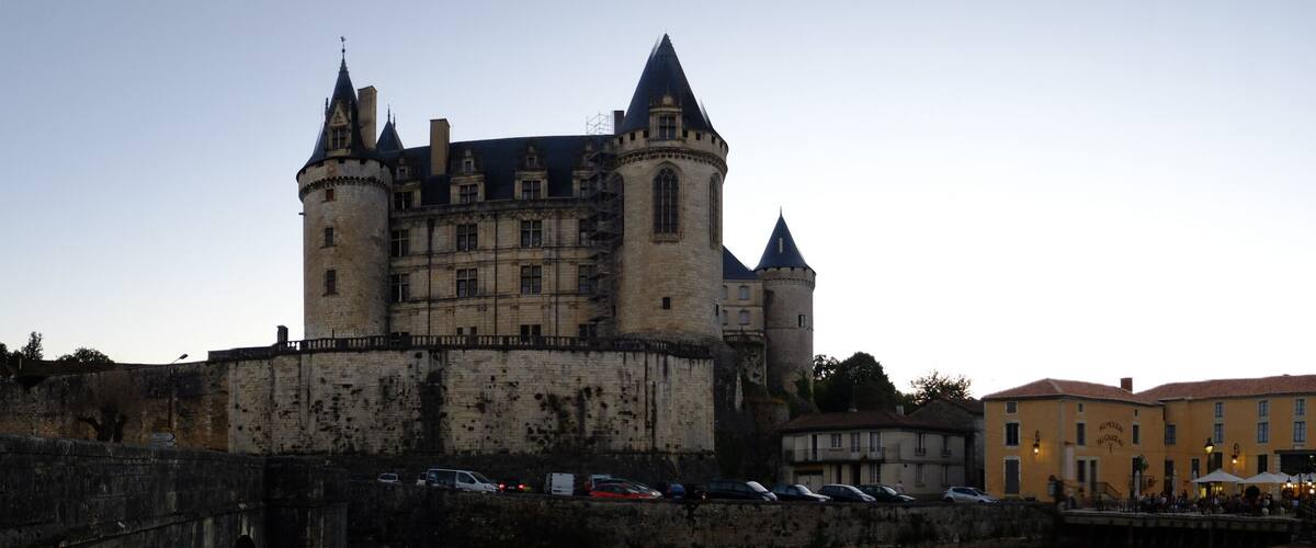 A historic castle with multiple towers and a fortified wall.