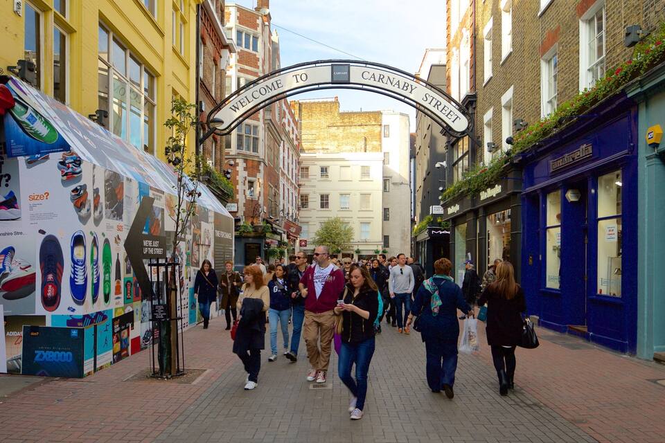 A bustling street with a 'Welcome to Carnaby Street' archway, vintage shops, and pedestrians.