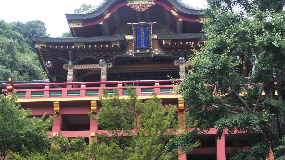 A traditional temple with ornate architecture, surrounded by lush greenery.