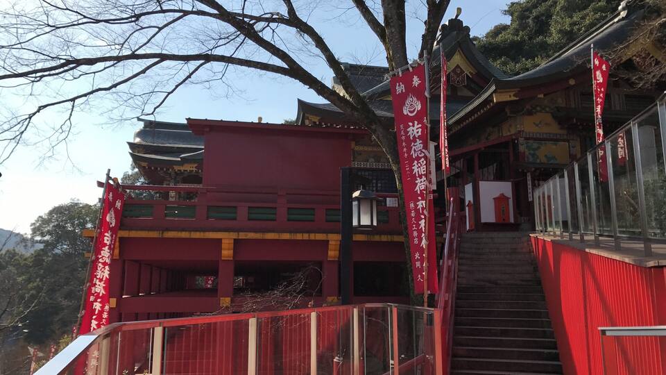A traditional building with red and yellow walls, a staircase, and red banners with white text.