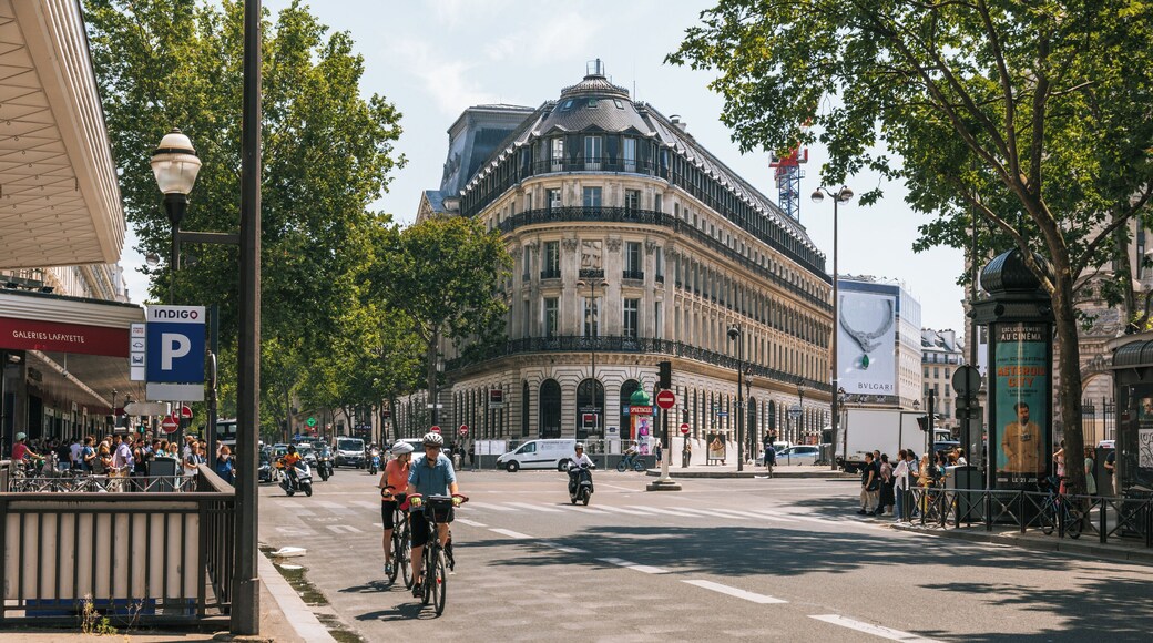 En livlig bygate med historisk arkitektur, cyklister og fotgjengere.