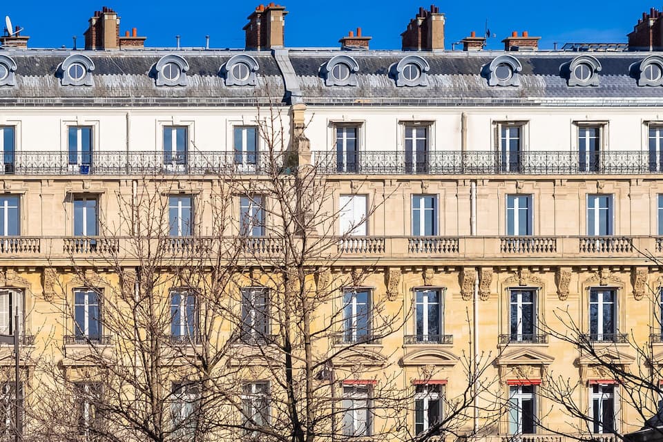 A row of historic buildings with ornate facades and multiple windows.