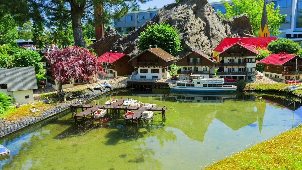 A model village with a river, boats, and colorful houses.