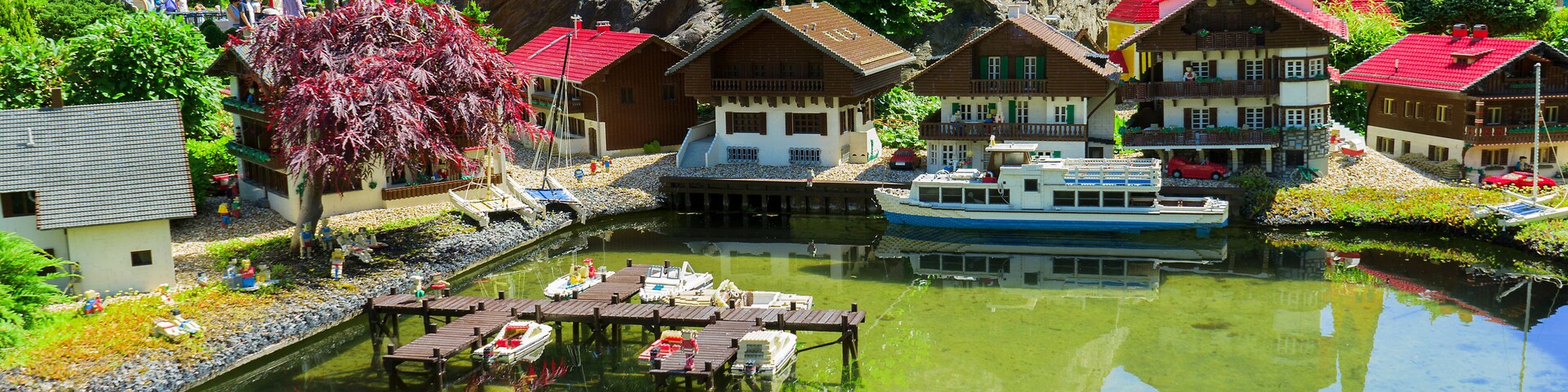 Un pueblo modelo con un río, barcos y casas de colores.