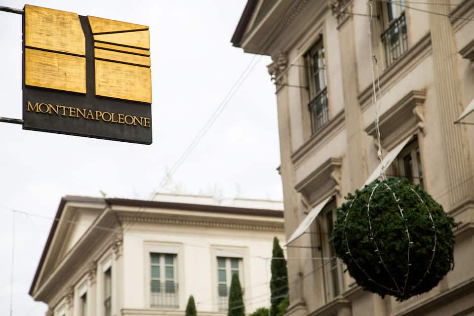 A sign with 'MONTENAPOLEONE' and a building with classical architecture.
