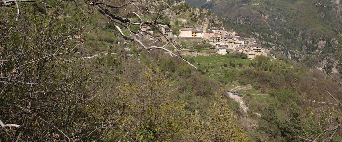 A mountainous village nestled in a valley with rocky terrain and sparse vegetation.
