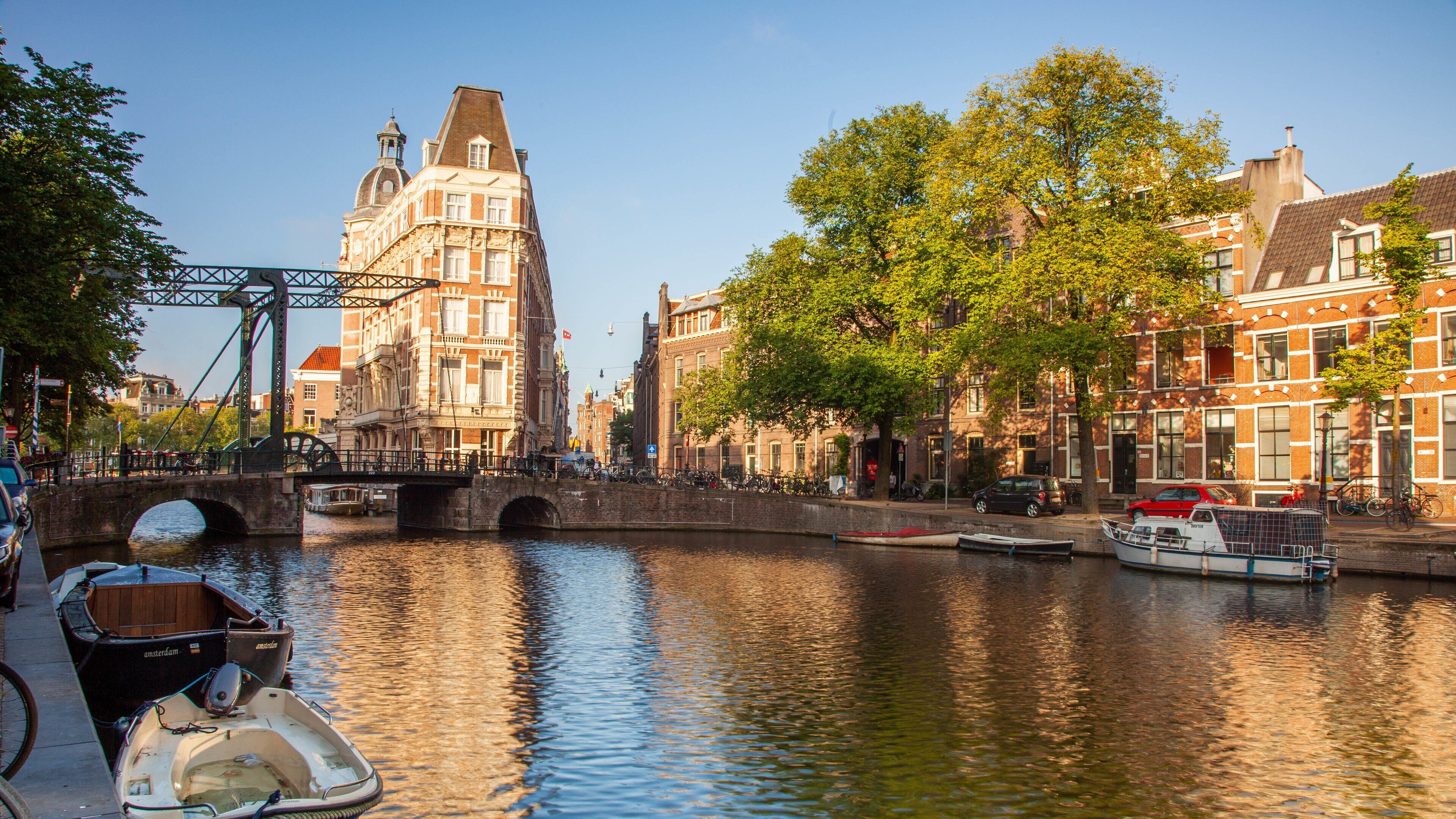 A canal with boats, a bridge, and historic buildings.
