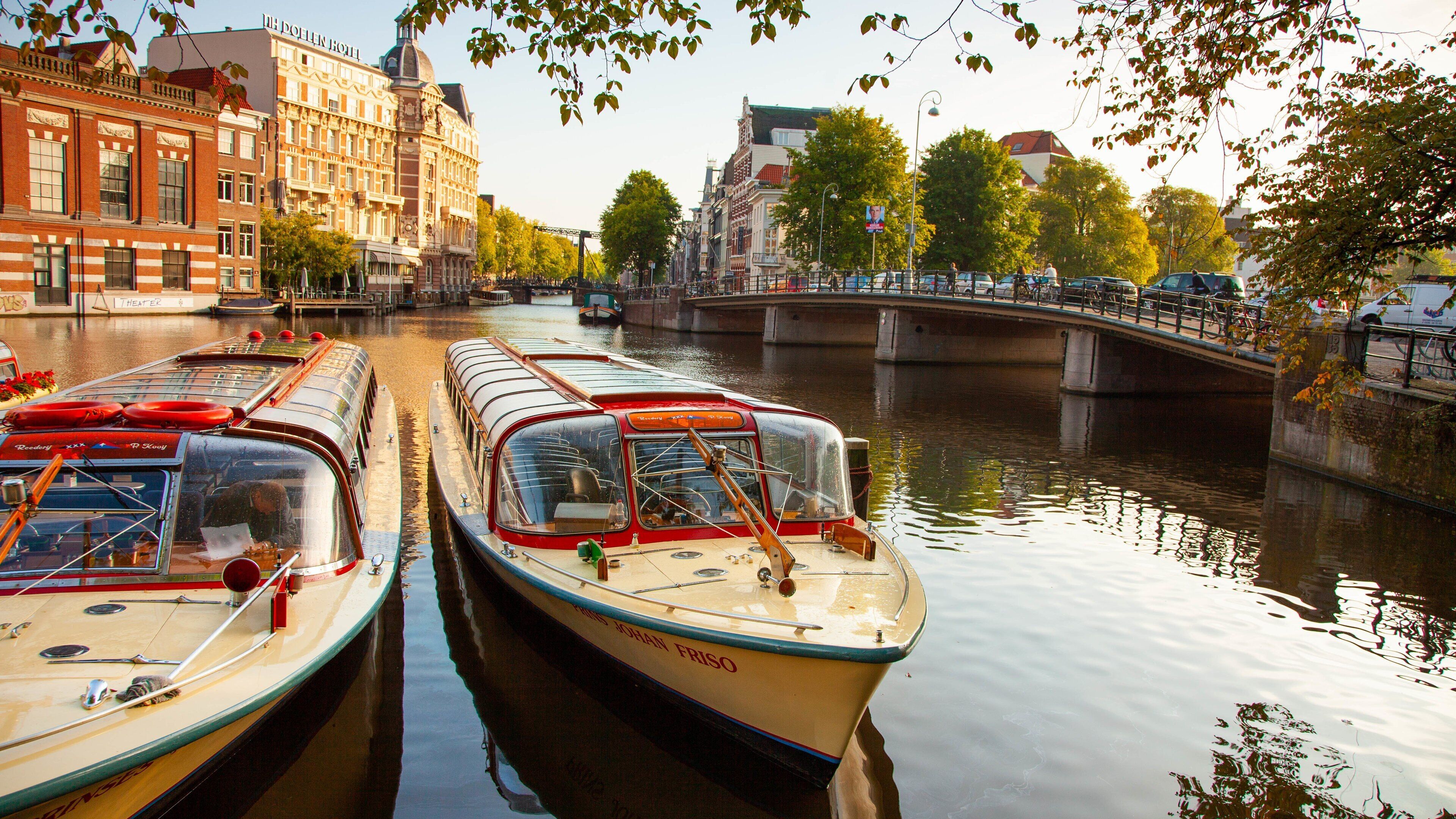 A canal with boats, a bridge, and buildings.