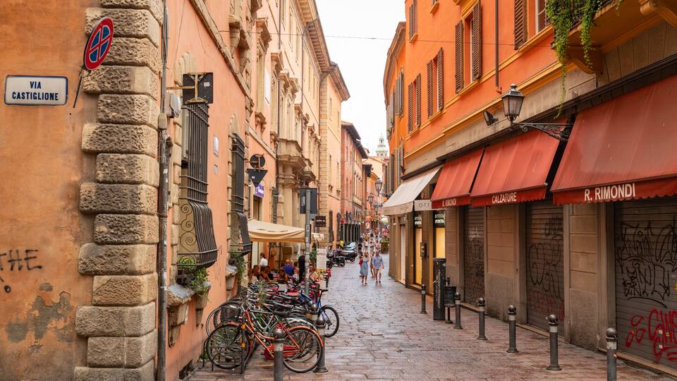A narrow cobblestone street lined with historic buildings, bicycles parked along the side, and a few pedestrians walking.