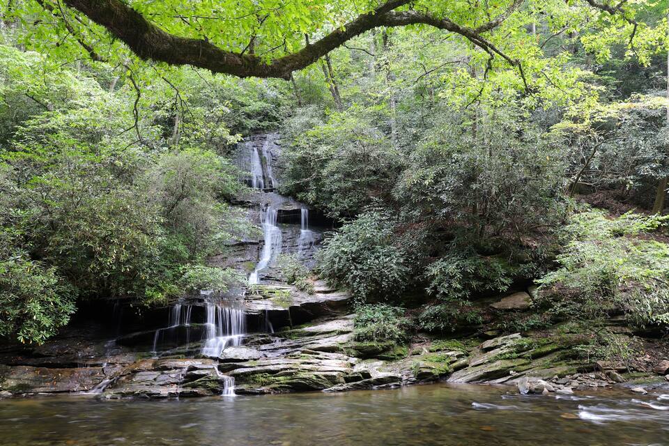 A waterfall cascading over rocks in a forested area.