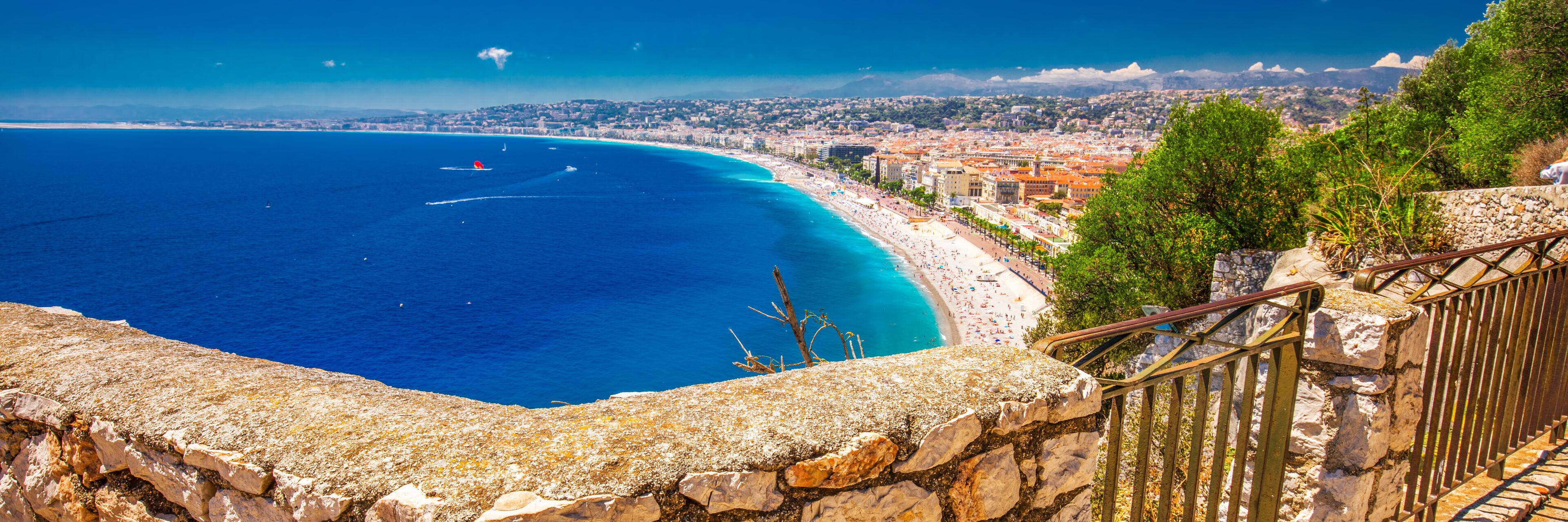 Una ciudad costera con una playa, una escalera de piedra y vistas al océano.