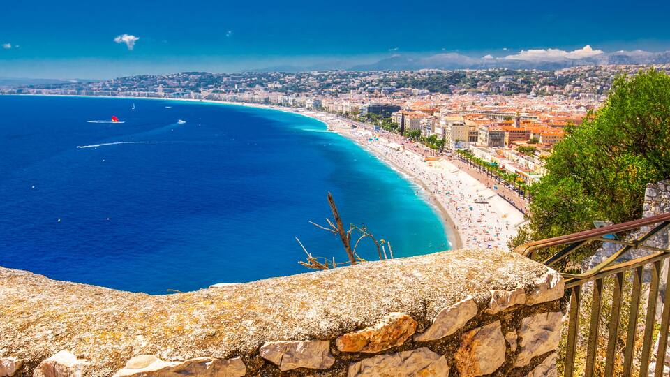 Una ciudad costera con una playa, una escalera de piedra y vistas al océano.