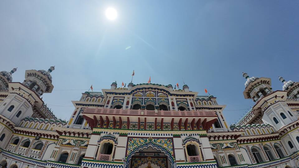 A grand, intricately designed building with multiple domes and arches, under a clear sky.