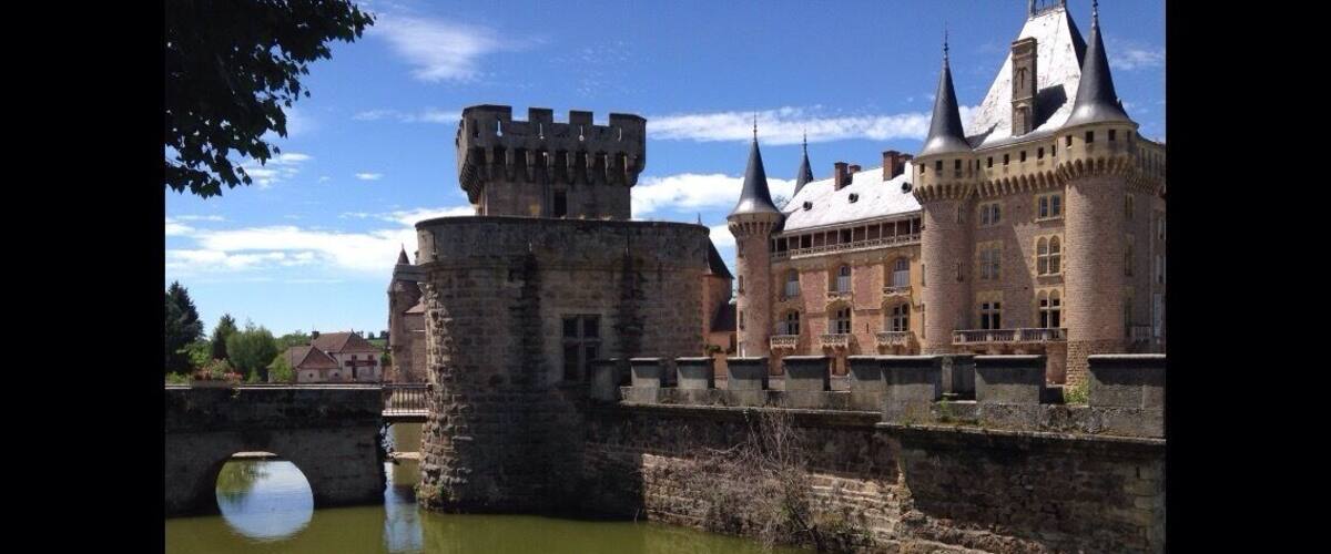 A historic castle with a moat and a bridge.