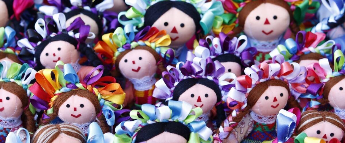 A collection of dolls adorned with colorful ribbons and bows.