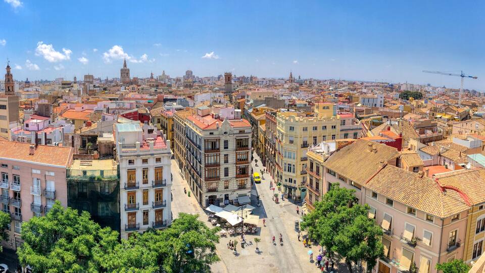 Una vista panorámica de una ciudad densamente construida, con edificios históricos y una torre destacada.