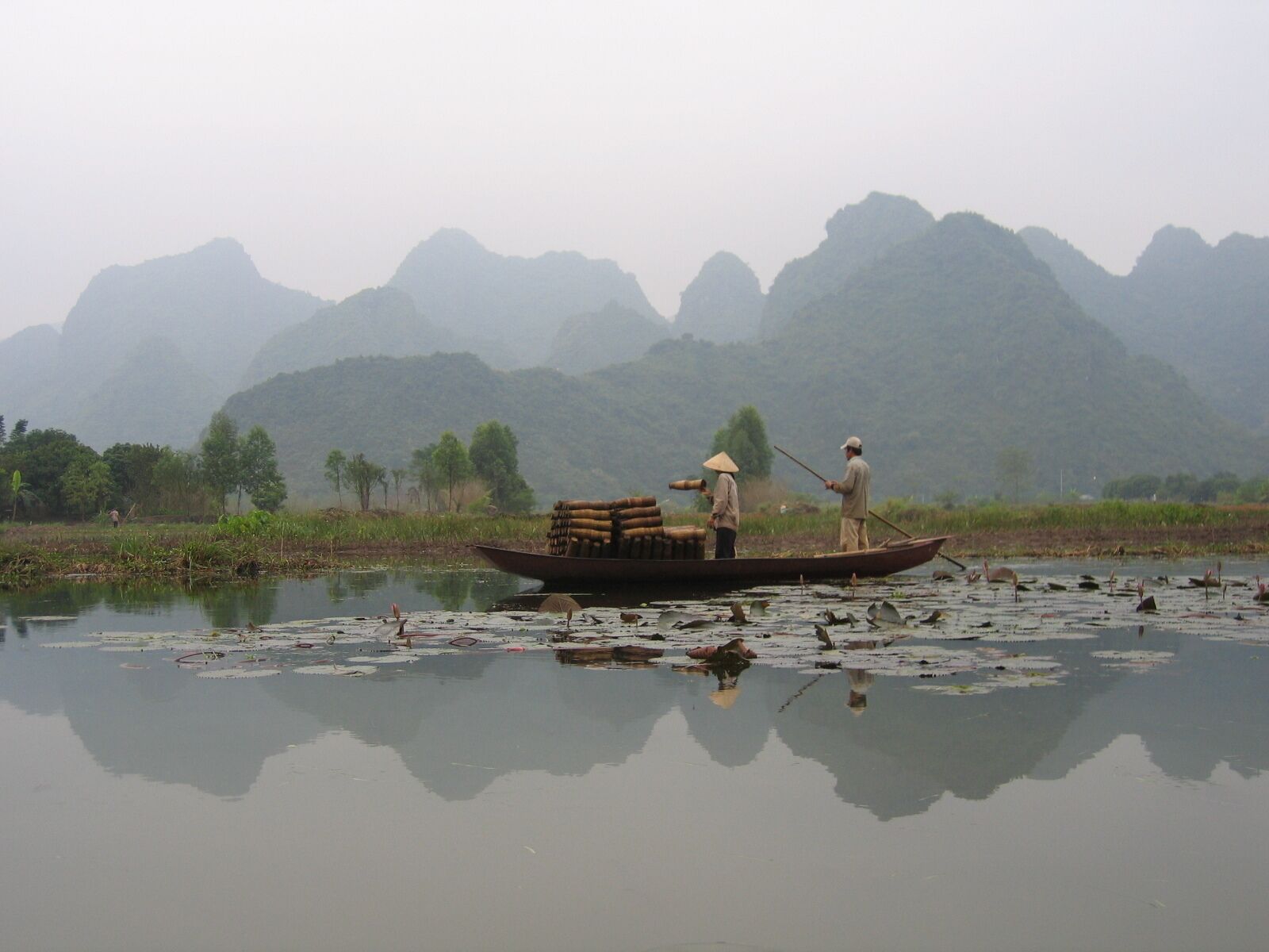 One of my favorite pictures ever.  I love the mist, the mountains, the perfect reflection, the tradition clothing, the shrimp basket.  
