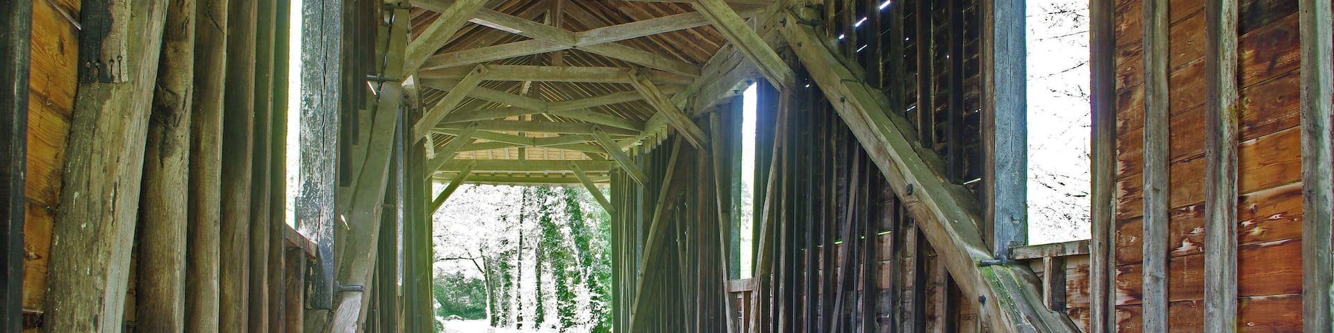 Le Pont-ChrĂ©tien-Chabenet (Indre). Le pont couvert. Le pont de bois, couvert, enjambe la Bouzanne. Ce pont doit ĂȘtre, en France, le seul ouvrage en bois entiĂšrement couvert (le pont couvert moderne de Saint-Gervais-sous-Meymont reste une exception, il n'est pas fermĂ© sur les cĂŽtĂ©s). ClassĂ© monument historique le 20 juillet 1992, son Ă©dification a Ă©tĂ© autorisĂ©e par la prĂ©fecture de lâIndre en 1855 suite Ă une demande du Comte de Poix, seigneur de Chabenet. Le pont a Ă©tĂ© restaurĂ© en 2001. Selon la version locale, le pont couvert aurait Ă©tĂ© bĂąti, entre 1847 et 1854, lors de la construction du tronçon ChĂąteauroux/Argenton-sur-Creuse du chemin de fer du Centre (ligne Paris-Toulouse), pour permettre aux ouvriers italiens travaillant au percemement du tunnel et au chemin du viaduc des Roches, de franchir quotidiennement la Bouzanne. La traversĂ©e de la Bouzanne, effectuĂ©e jusque lĂ en barque, avait coĂ»tĂ© le vie Ă neuf d'entre eux le 20 avril 1847, leur embarcation ayant Ă©tĂ© emportĂ©e par une crue. En outre la couverture du pont offrait un abri pour le repas des ouvriers. Selon une autre version, le pont aurait Ă©tĂ© construit vers 1860 par le comte de Poix pour desservir ses domaines. Le tronçon ChĂąteauroux-Limoges de la ligne Paris-Toulouse sera confiĂ© au jeune ingĂ©nieur Jules Carvallo*, nĂ© en 1820 au sein d'une famille d'origine juive portugaise. Peu de temps aprĂšs sa sortie des Ăcoles polytechnique et des ponts et chaussĂ©es, Il doit donc superviser la rĂ©alisation du tunnel des Roches et le viaduc enjambant la Bouzanne*. Il va ĂȘtre confrontĂ© Ă la dure rĂ©alitĂ© du terrain. "Les chantiers de chemins de fer avaient la rĂ©putation d'ĂȘtre ingĂ©rables. Ils rĂ©unissaient un nombre impressionnant d'ouvriers, de corps de mĂ©tiers et de provenances gĂ©ographiques. Les conditions de vie et de travail y Ă©taient en outre Ă©pouvantables. C'est pourquoi les bagarres Ă©taient quotidiennes et d'une grande violence." (LĂ©andre Boizeau*) Jules Carvallo, qui n'a pas encore 30 ans, sera donc confrontĂ© Ă la noyade des neuf ouvriers qui traversaient la Bouzanne en crue, il devra Ă©galement s'interposer, armĂ©, Ă des ouvriers grĂ©vistes, il sera mĂȘme accusĂ© d'actes crapuleux. AprĂšs ce sĂ©jour mouvementĂ© au Pont-ChrĂ©tien de1845 Ă 1852, l'homme est devenu "influent, respectable et respectĂ©." Les difficultĂ©s de Carvallo s'inscrivent dans une pĂ©riode, par ailleurs plutĂŽt tragique dans la rĂ©gion, avec les Ă©meutes de Buzançais. Dans les campagnes de lâIndre, durant l'hiver de 1846/1847, la maladie de la pomme de terre, la spĂ©culation sur le blĂ© et le chĂŽmage saisonnier aggravent les conditions de vie trĂšs prĂ©caires du petit peuple des villages, journaliers agricoles et artisans. On se rĂ©volte contre les profiteurs, les usuriers, les propriĂ©taires. La âJacquerie de Buzançais*â restera l'affaire la plus considĂ©rable, mais ce ne sera pas la seule, 35 localitĂ©s de l'Indre veront des Ă©meutes. La radicalitĂ© des actions et la duretĂ© de la rĂ©pression, provoquent la rĂ©action de personnalitĂ©s, comme George Sand*, Gustave Flaubert, Victor Hugo, ou encore Karl Marx*. Le trajet aurait pu, sans doute, ĂȘtre plus simple et moins coĂ»teux, mais on peut penser que le Comte De Poix, important actionnaire des chemins de fer dâOrlĂ©ans, a fait revoir le tracĂ© pour quâil Ă©vite ses vignes et son chĂąteau. Son wagon spĂ©cialement amĂ©nagĂ© Ă©tait stationnĂ© en gare de Chabenet. LĂ©andre Boizeau, instituteur dans l'Indre, l'un des membres fondateurs du magazine saisonnier (plus quelques numĂ©ros spĂ©ciaux) berrichon, la Bouinotte. Jules Carvallo (1820-1915), publiera une "Ă©tude sur la StabilitĂ© des voĂ»tes" en 1853. En 1860, il sera l'un des six signataires de l'appel fondateur de "l'Alliance IsraĂ©lite universelle". Cette fondation est une consĂ©quence de l'affaire de Damas (suite de la disparition dâun moine franciscain Ă Damas, des Juifs de la ville, accusĂ©s de crime rituel, sont arrĂȘtĂ©s et torturĂ©s ; certains meurent), et de l'affaire Mortara. (Edgardo Mortara, nĂ© en 1851 dans une famille juive de Bologne, est enlevĂ© par les autoritĂ©s papales car il avait Ă©tĂ© baptisĂ© Ă lâĂąge dâun an par la servante catholique de la famille. Il nâest jamais rendu Ă sa famille et devient mĂȘme prĂȘtre). Au cours d'une Ă©meute Ă Buzançais, initiĂ©e par le vol d'un convoi de blĂ© - 1060 dĂ©calitres - motivĂ© par la famine, entre le 13 et le 15 janvier 1847, des Ă©meutiers tentent d'assassiner le meunier Cloquemin et les propriĂ©taires Brillant et Gaulin aprĂšs avoir pillĂ© leurs maisons. Enfin, battent Ă coups de bĂąton, de fourche et de sabots M.Huard-Chambert, propriĂ©taire bourgeois qui avait tirĂ© pour se dĂ©fendre sur Venin, chef des Ă©meutiers, l'abattant net. 26 accusĂ©s seront jugĂ©s par la Cour d'assise de l'Indre (le jury a Ă©tĂ© recrutĂ© chez les propriĂ©taires, on Ă©cartera le seul jurĂ© qui serait "hostile" au gouvernement) pour "pillage, assassinat, tentatives d'assassinat et d'incendie". Les avocats des Ă©meutiers, maĂźtres Protade-Martinet et Rollinat, (le pĂšre de lâĂ©crivain Maurice Rollinat) mettent en avant la misĂšre du peuple dans son ensemble : « Le peuple ne sait, ne voit quâune seule chose, câest quâon emporte au loin le blĂ©, sa seule nourriture », « Les accusĂ©s nâont Ă©tĂ© que des instruments qui ont exĂ©cutĂ© une sentence prononcĂ©e par la multitude ». Le 4 mars 1847, Baptiste Bienvenu, Louis Michot et François Velluet, seront condamnĂ©s Ă mort par le tribunal de ChĂąteauroux, quatre aux travaux forcĂ©s Ă perpĂ©tuitĂ©, les dix-huit autres Ă des peines plus ou moins fortes, et Ă l'exposition publique sur la place de Buzançais, un seul sera acquittĂ© (Bezard). Baptiste Bienvenu, Louis Michot et François Velluet seront guillotinĂ©s en place publique, Ă Buzançais, le 16 avril 1847. Les trois guillotinĂ©s du 16 avril, sont : - Louis Michot, 20 ans, ouvrier sabotier, cĂ©libataire, hab. ChĂąteauroux, rue des Ponts. - François Velluet, 37 ans, garde particulier, mariĂ© 4 enf., hab Bonneau commune de Sainte-Gemme. - Baptiste Bienvenu, 25 ans, journalier, cĂ©libataire, hab. Buzançais. George Sand Ă©crit Ă son cousin en fĂ©vrier 1847 "Câest affreux, et entre ceux qui vont comparaĂźtre aux assises et ceux qui vont les accuser, je ne sais trop lesquels ont mĂ©ritĂ© les galĂšres". "La maladie de la pomme de terre et les mauvaises rĂ©coltes de 1845 et de 1846 accentuĂšrent l'effervescence gĂ©nĂ©rale dans le peuple. Le renchĂ©rissement de la vie en 1847 provoqua en France comme sur tout le reste du continent des conflits sanglants. Face aux orgies scandaleuses de l'aristocratie financiĂšre, c'Ă©tait la lutte du peuple pour les moyens d'existence les plus Ă©lĂ©mentaires ! A Buzançais, on exĂ©cuta les Ă©meutiers de la faim Ă Paris des escrocs repus Ă©taient soustraits aux tribunaux par la famille royale !". (K. Marx - Les luttes de classes en France)