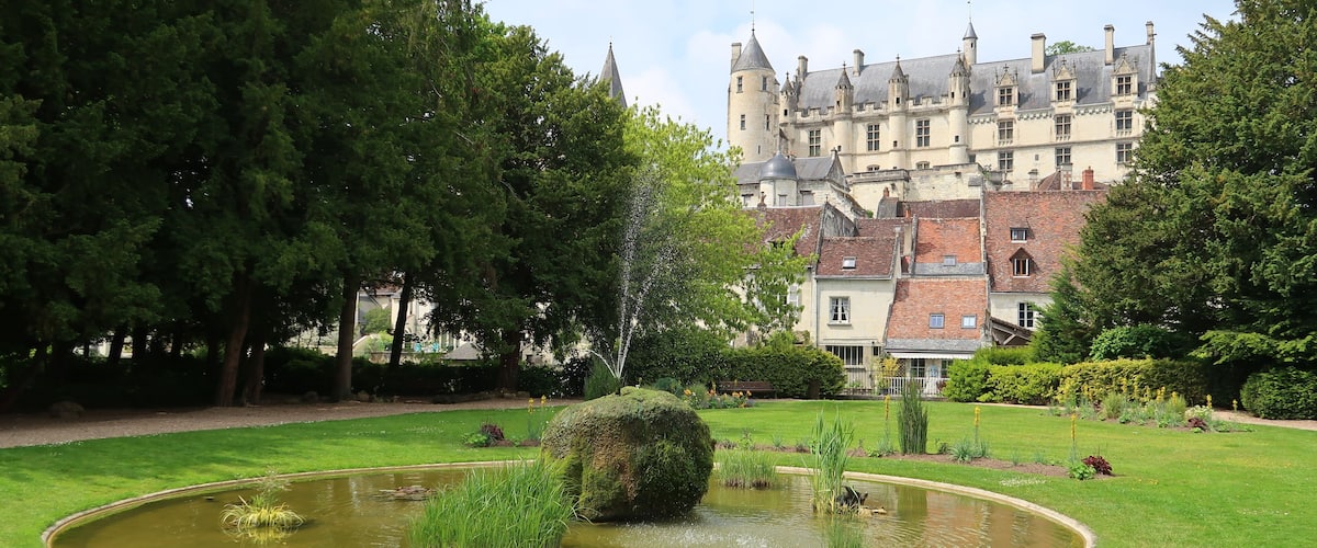 Logis royal du château de Loches vu depuis un jardin public, avec une fontaine (France)