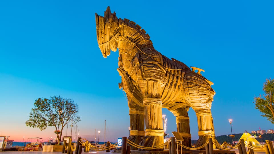A large, illuminated horse sculpture at dusk.
