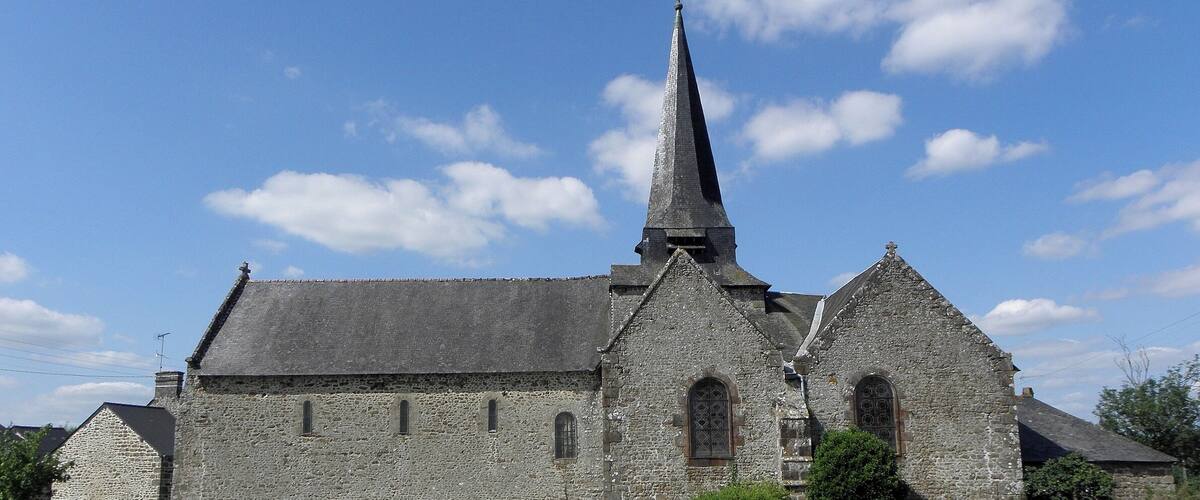 A stone church with a tall spire and arched windows.