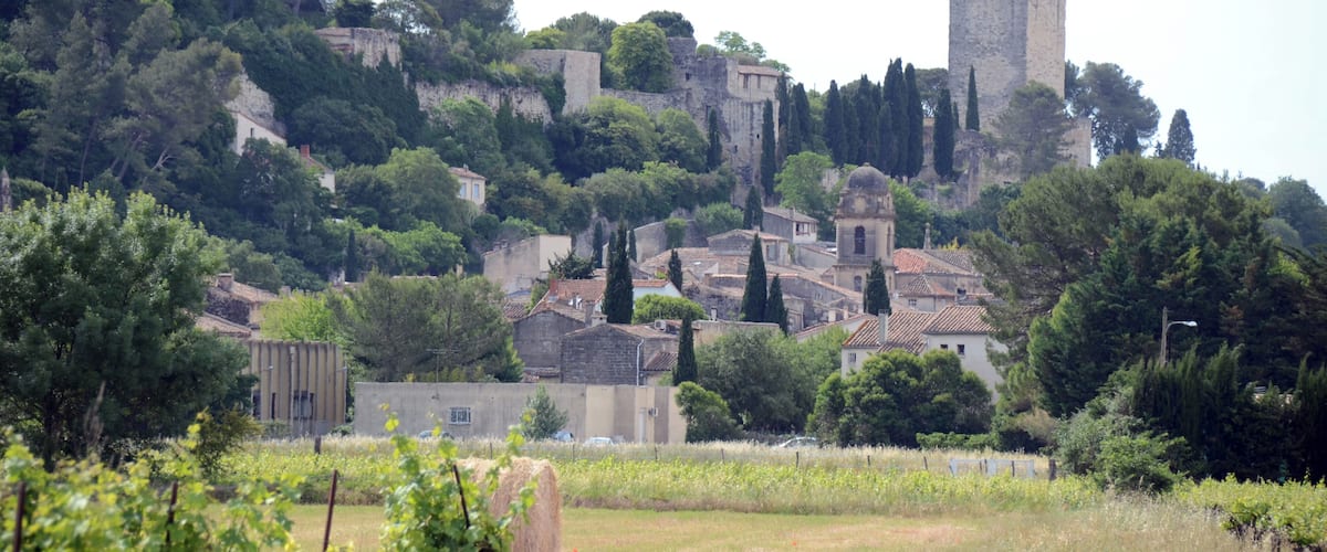 A hillside village with historic stone buildings and a prominent tower.