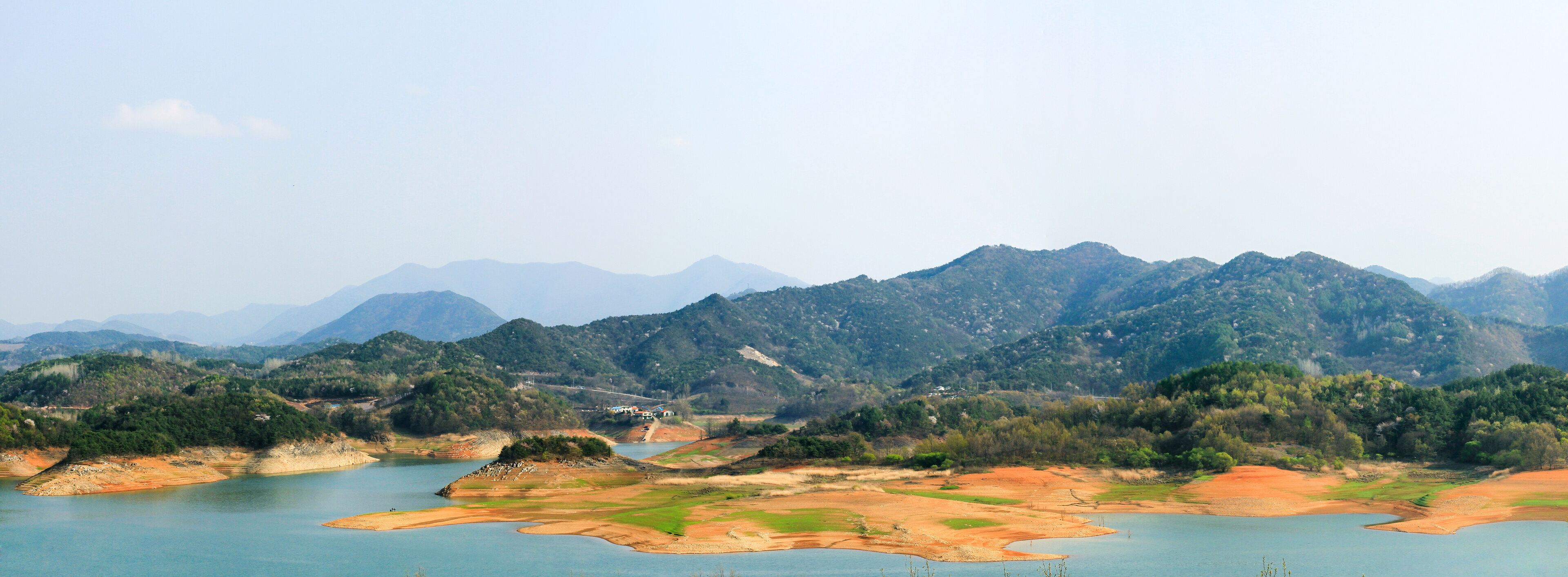 A mountainous landscape with a river and a small lake.