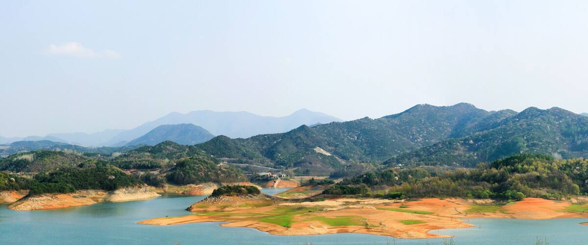 A mountainous landscape with a river and a small lake.