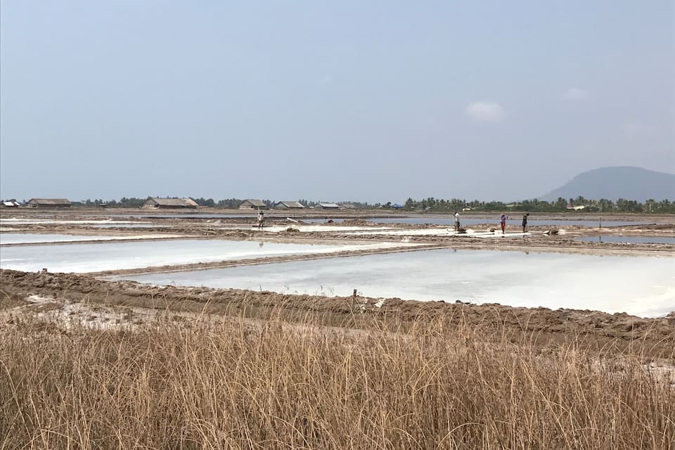A landscape with multiple water bodies and dry grass in the foreground.