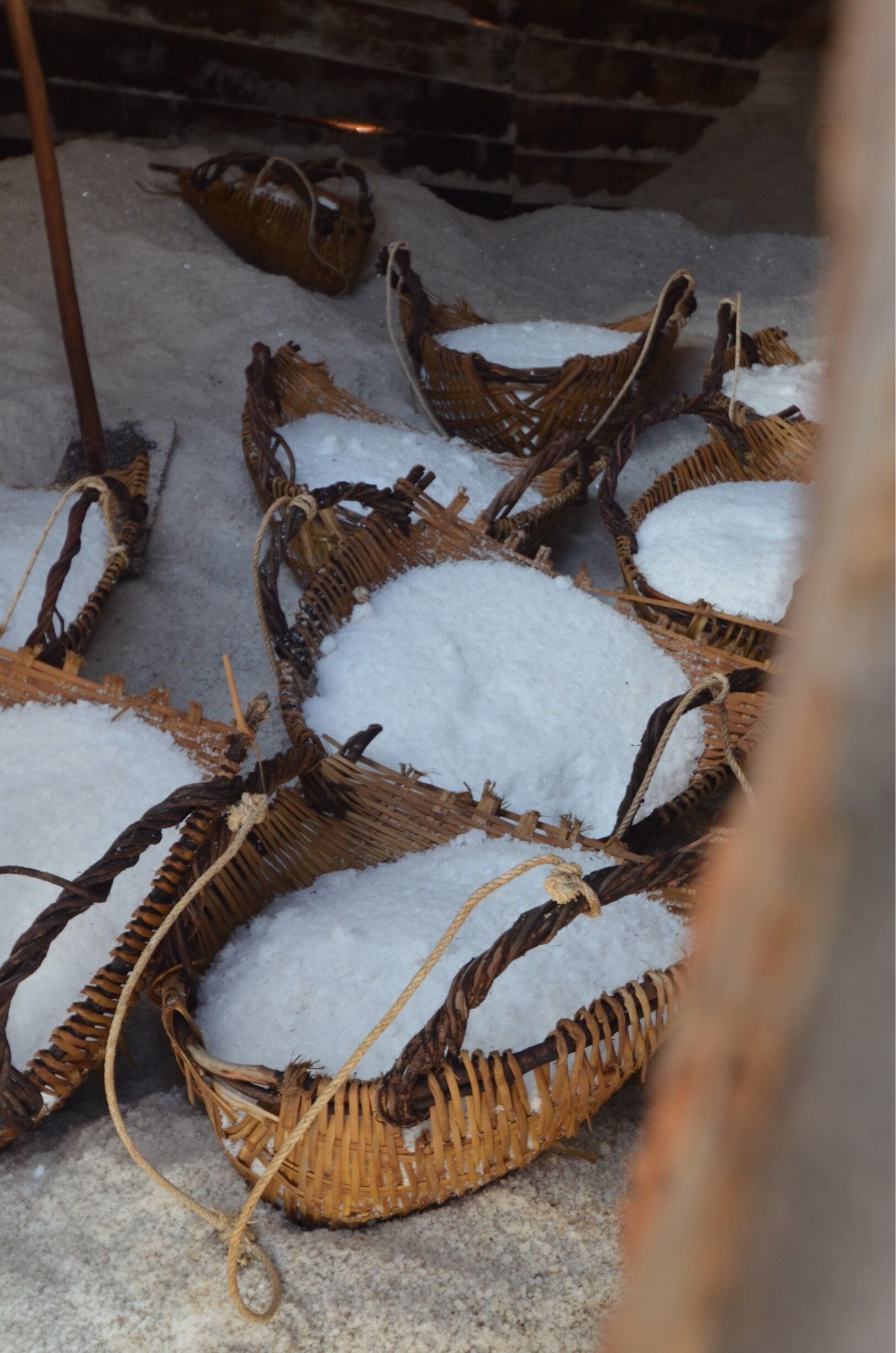 Wicker baskets filled with snow on a concrete surface.