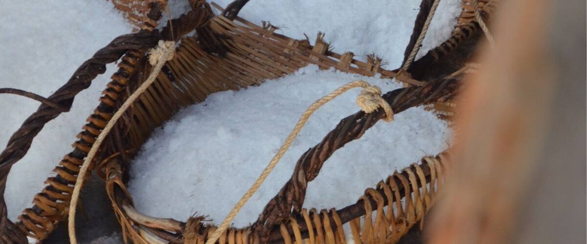 Wicker baskets filled with snow on a concrete surface.