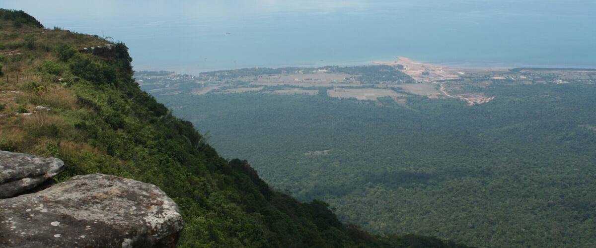 A mountainous landscape with a view of a coastal area and a river.
