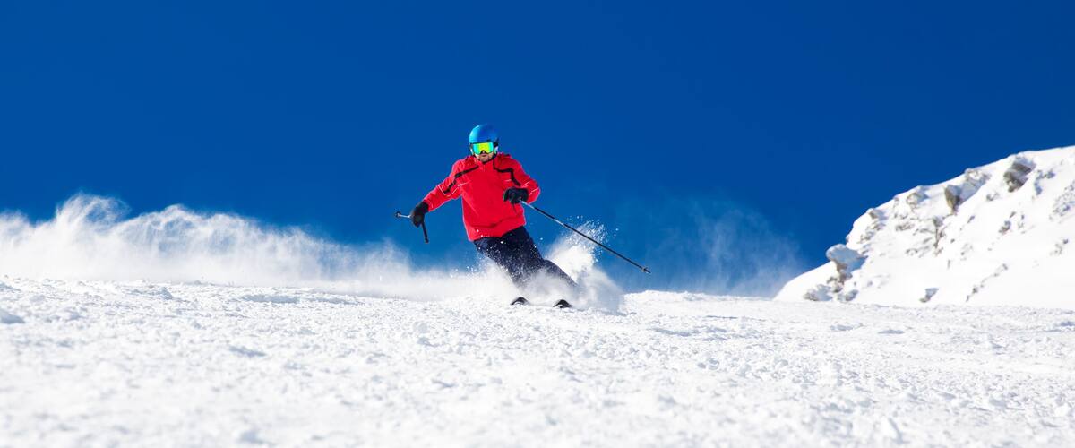 Man skiing on the prepared slope with fresh new powder snow
