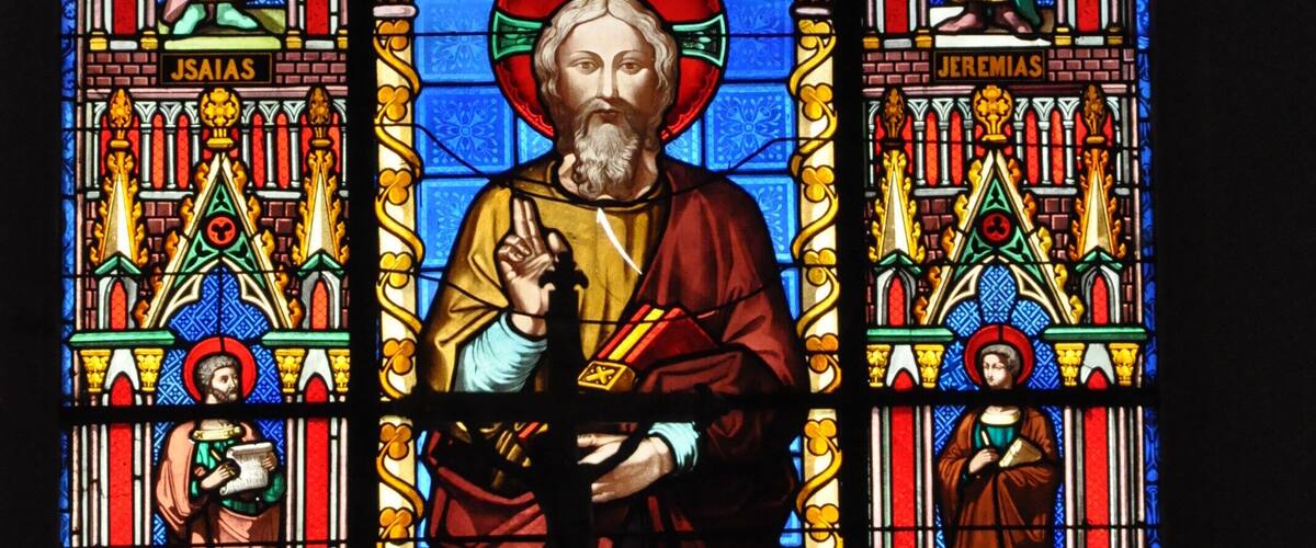 A stained glass window with religious figures and architectural details.