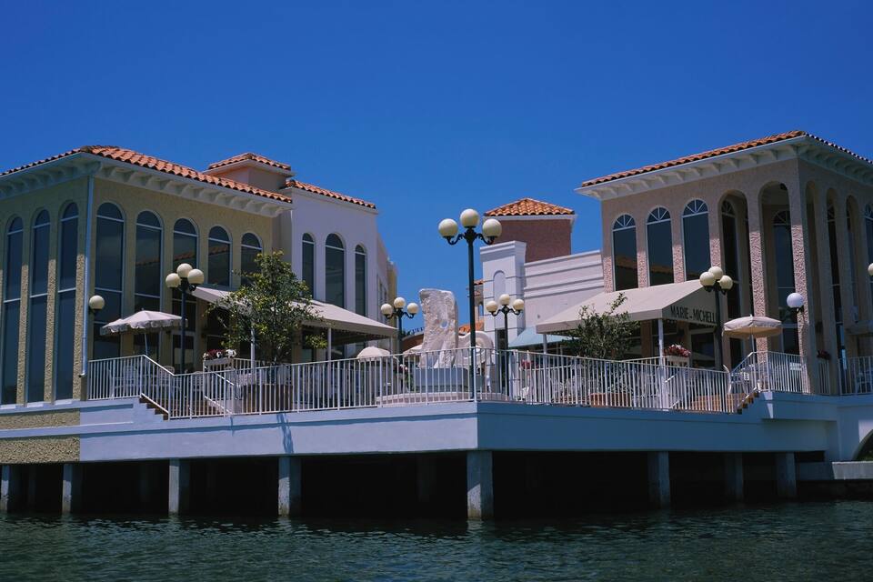 A waterfront building with arched windows and a red-tiled roof.